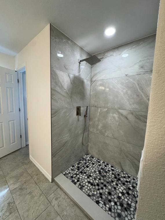 Curbless walk-in shower with marble-look slab walls
