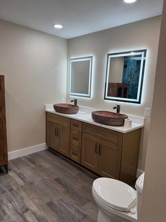 Double vanity with vessel sinks and backlit mirrors