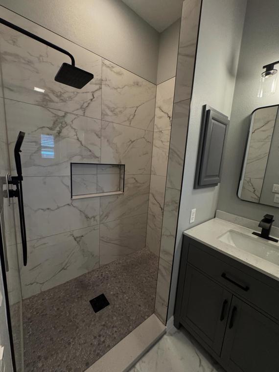 Master shower rebuilt with matte black trim and tile niche