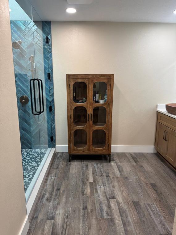 Herringbone tile shower with custom vanity cabinet