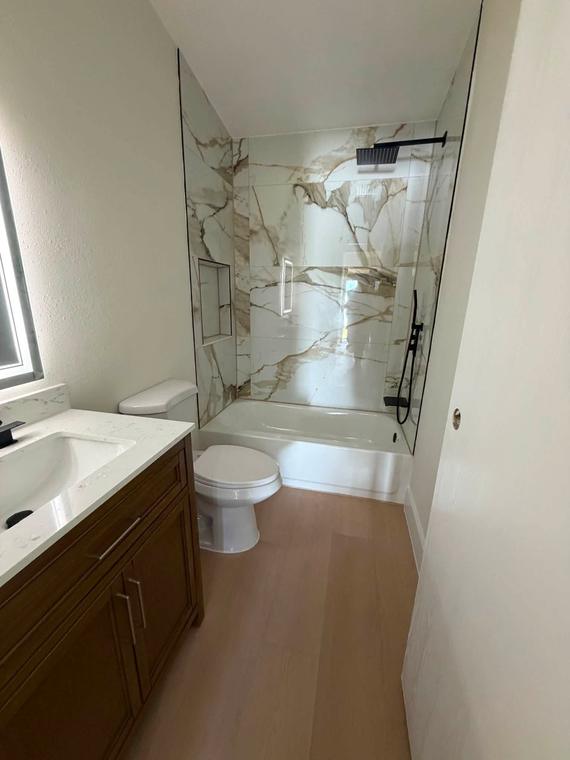 Guest bath with new tub surround, vanity and flooring