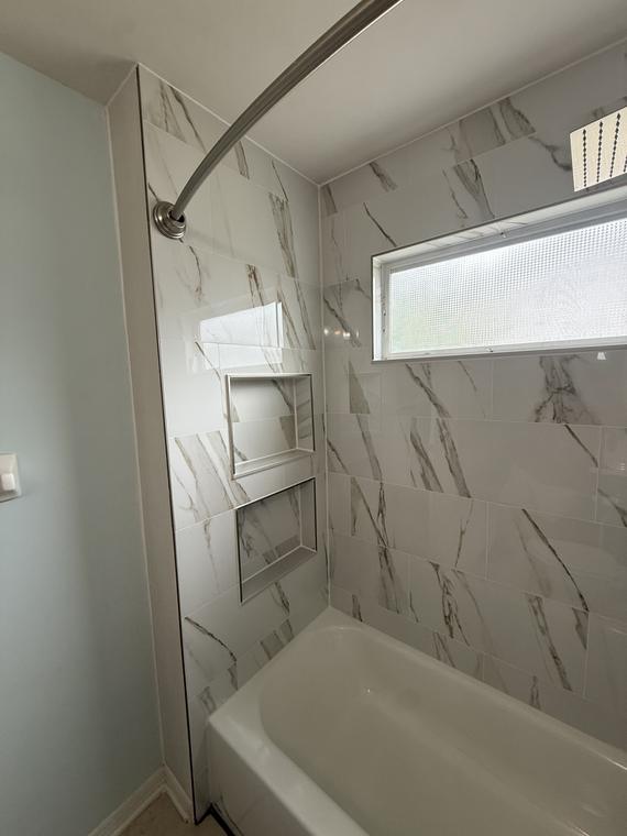 Recessed shower niche set into the new porcelain surround