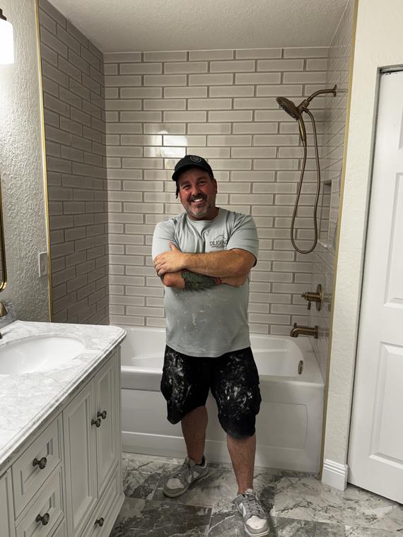 Finished bath with a subway-tile tub surround and grey marble-look floor