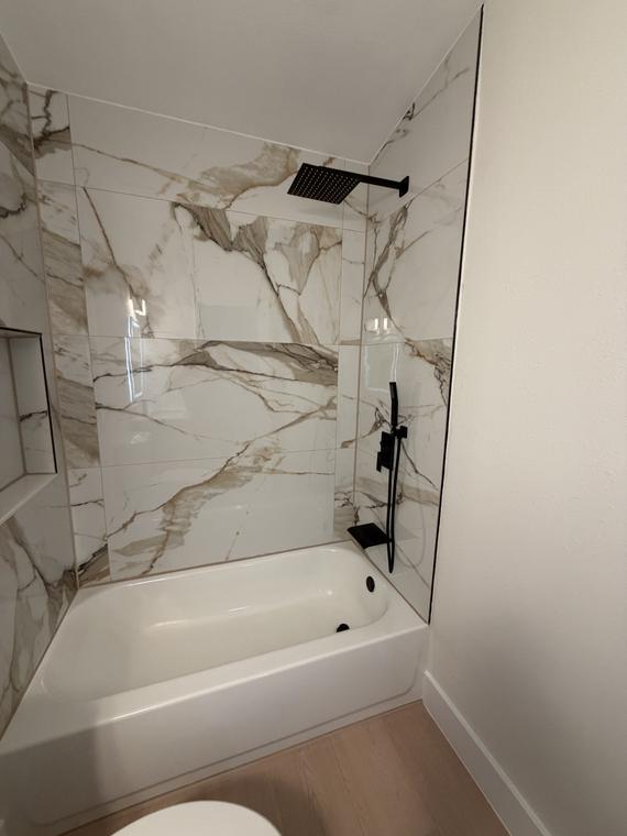 Book-matched porcelain tub surround with matte black fixtures