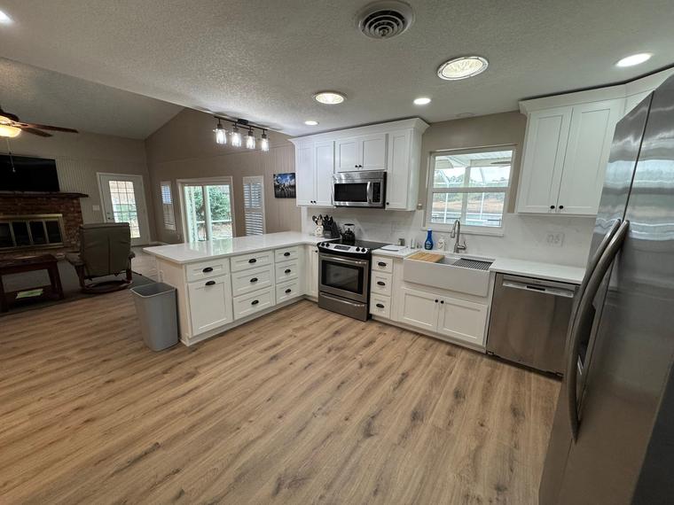 Open-concept kitchen with shaker cabinets and farmhouse sink
