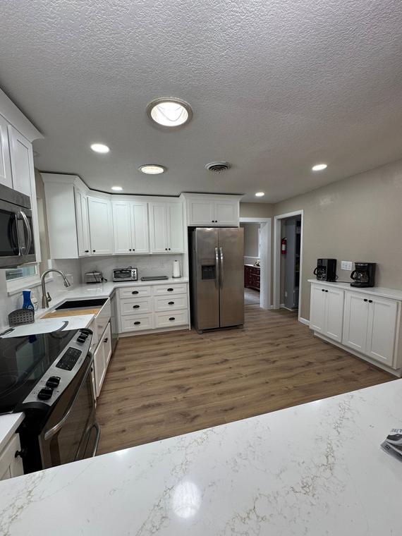 Bright white kitchen with quartz counters and recessed lighting