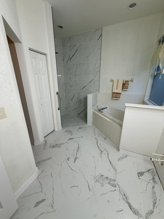 After — marble-look porcelain carried wall to wall across the room