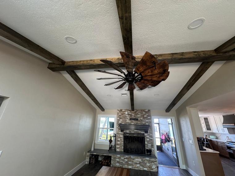 Faux wood beam ceiling and stacked stone fireplace
