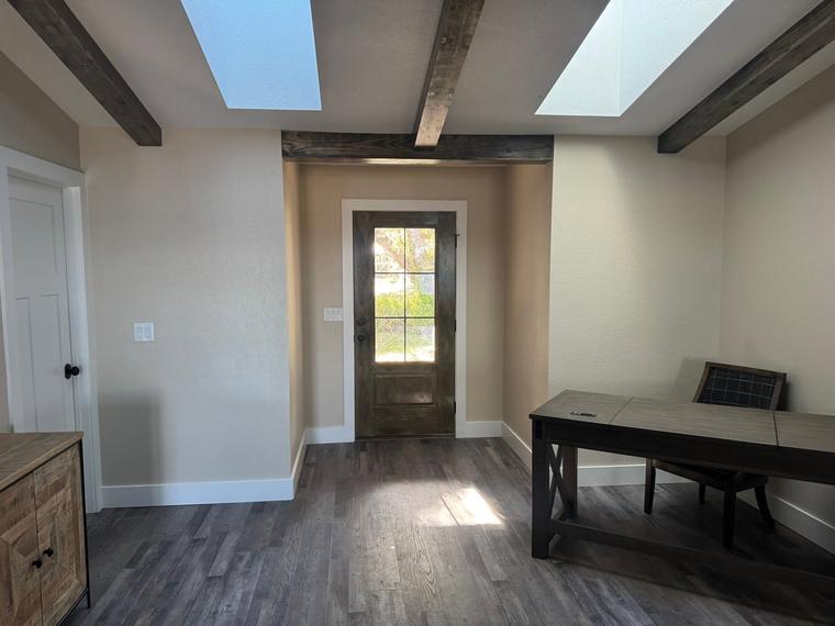 Beamed ceiling with skylights over new plank flooring